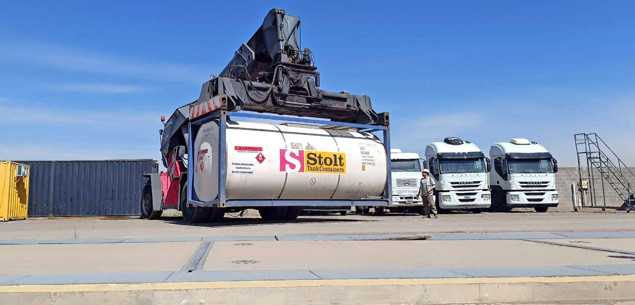 Reach stacker izando un ISO tank container Stolt en patio logístico